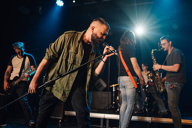 istock Rock band performing live on stage with passionate singer 2210390369