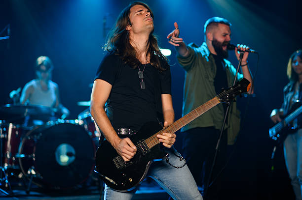 istock Rock band performing live on stage with passion 2210390372