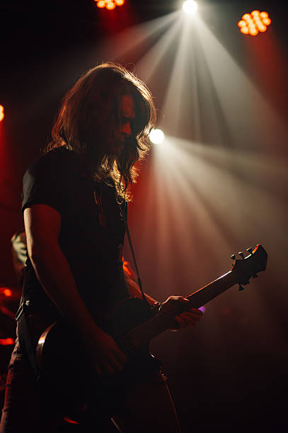 istock Guitarist performing on stage under red lights 2210390376