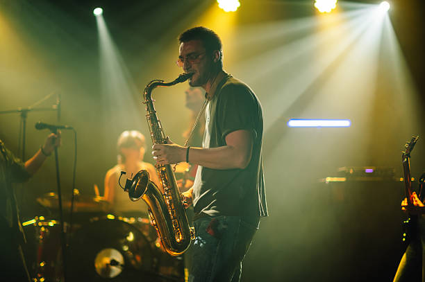 istock Saxophonist performing live on stage with band 2210390434