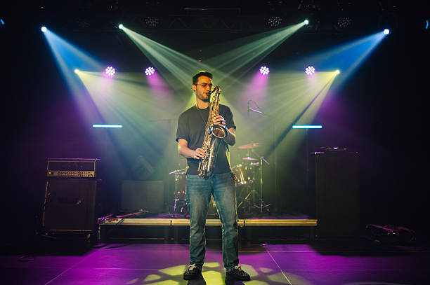 istock Saxophonist performing on stage under colorful lights 2210390448