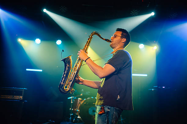 istock Saxophonist performing live on stage with spotlights 2210390450