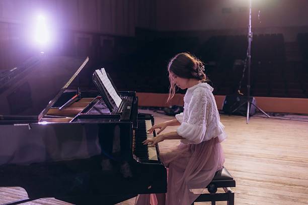 istock Woman Playing Piano on Stage During a Solo Performance 2210393835