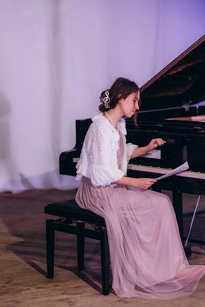 istock Elegant Woman in Evening Attire Practicing Piano in a Serene Setting 2210393865