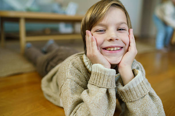 Cheerful baby boy lies on a white background and smiles.