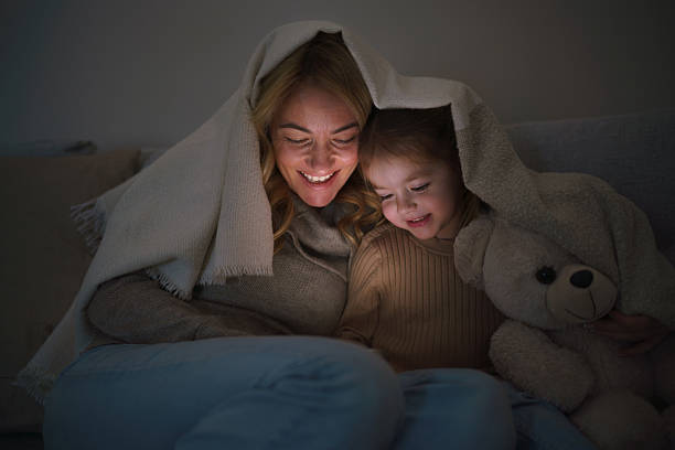 istock Mother and daughter using mobile phone at night 2210394467