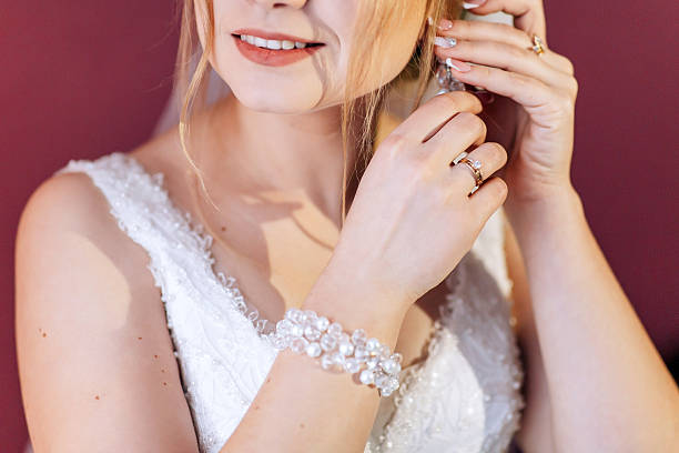istock A woman is getting ready for a wedding and is putting on her earrings 2210396917