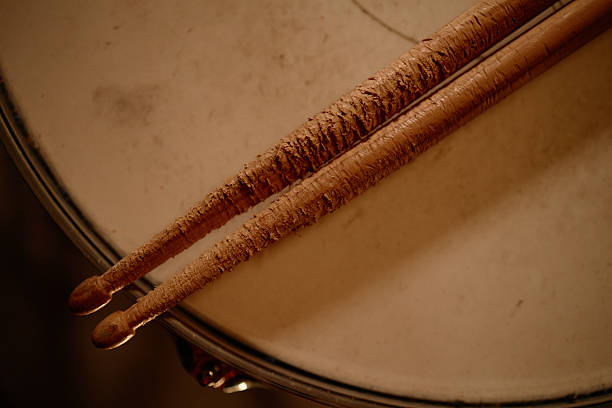 istock Worn out Wooden Drumsticks Placed on Drum in Studio with Dim Light 2210397832