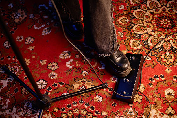 Womans Foot Pressing Guitar Pedal Board Controlling Effects Playing Rock in Studio