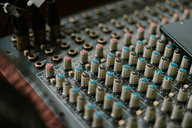 Close-up of a vintage audio mixing console with colorful knobs