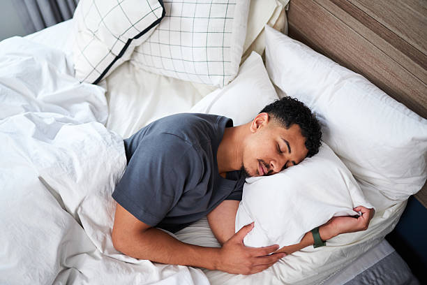 istock Young Man Relaxing in a Comfortable Bed During a Peaceful Night’s Sleep 2210398431
