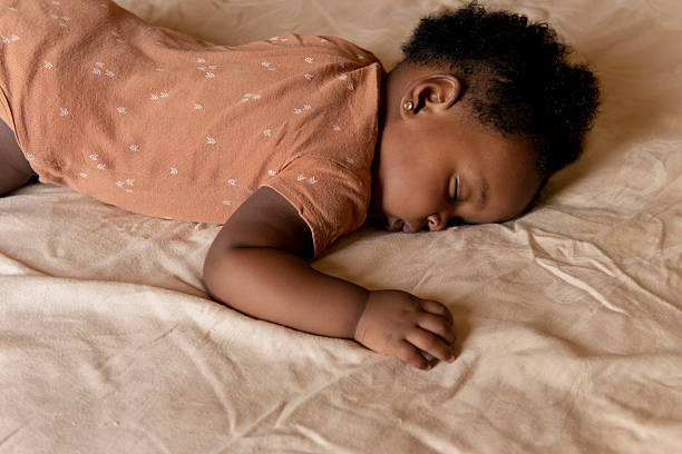 istock Baby girl sleeping peacefully on bed in soft light 2210400029