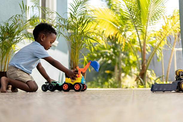 istock Little boy playing with toy trucks on a patio 2210400474