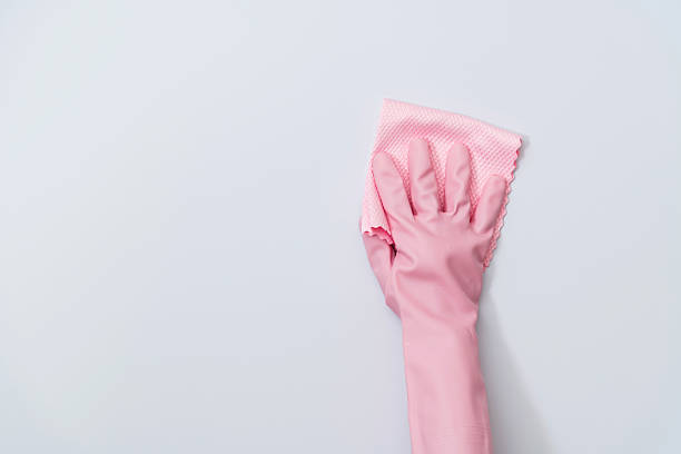 Woman hand cleaning white wall with rag.