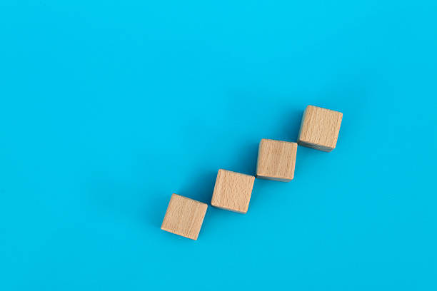 Wooden blocks as a staircase on blue background.