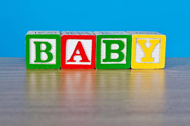 Little baby girl in diapers playing with toy blocks in bed
