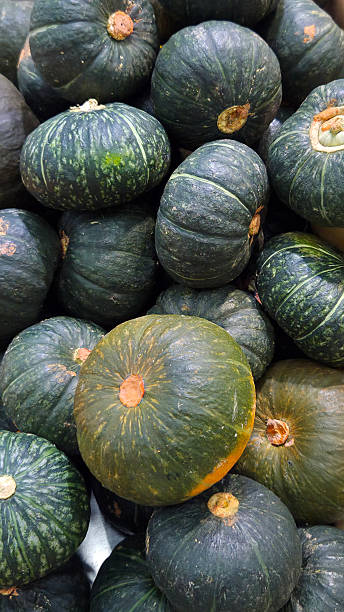 istock Green pumpkins stacked in a market 2210407272