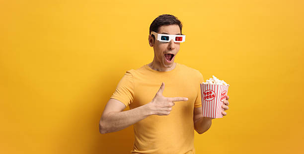 istock Happy man pointing at a box of popcorn 2210412673