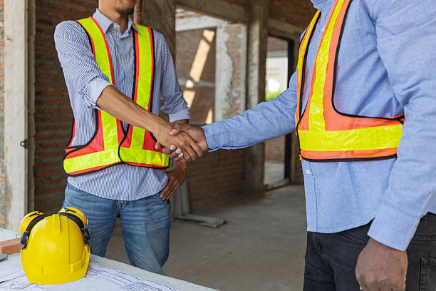 istock Construction workers shake hands at a job site during a project meeting 2210416444