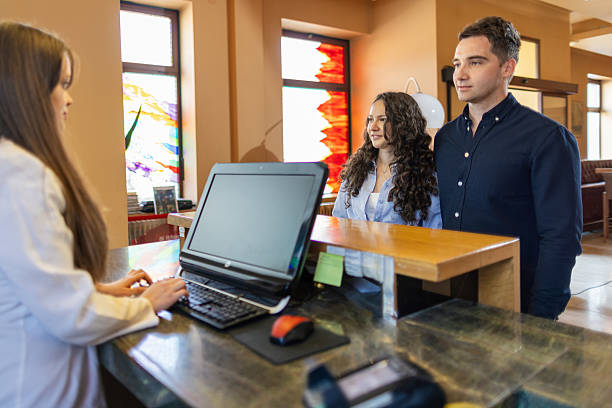 istock Young couple checking in a hotel reception desk 2210419309