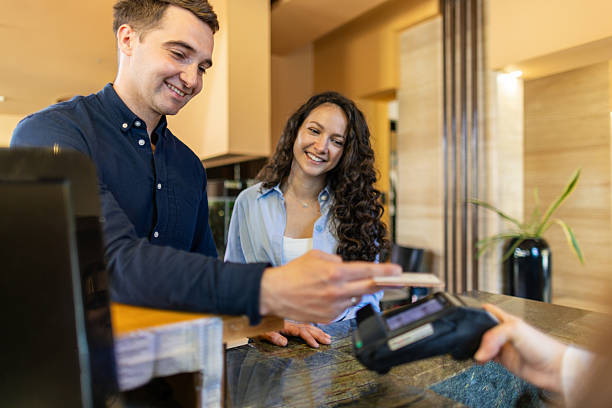 istock Young couple paying at hotel reception with credit card 2210419336