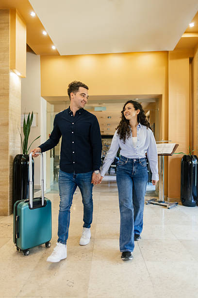 istock Young couple entering hotel lobby for check in 2210419440