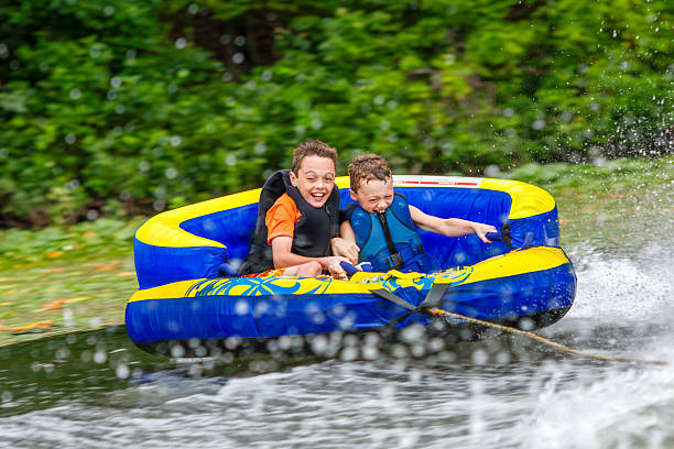 Boy enjoys a summer day at the lake jumping in a rubber ring.