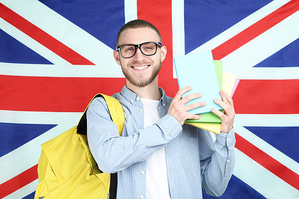istock Young man with backpack and books on British flag background 2210424895