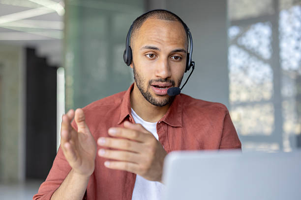 istock Man with headset and laptop talking using video call, support service worker at workplace inside office. Advises customers consumers. Business meeting remote conference 2210425888