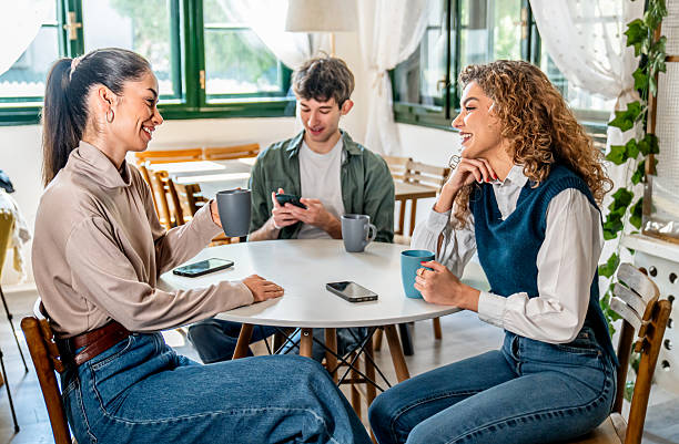 istock Young adults enjoying coffee and conversation at a cafe 2210427186
