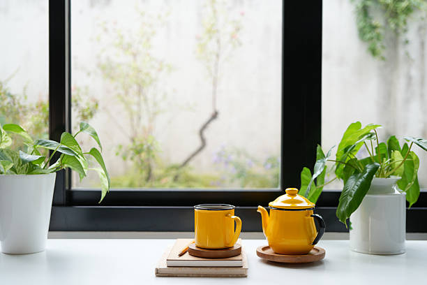 istock Yellow tea pot and cup set and plant pot, cozy indoor workspace 2210428810