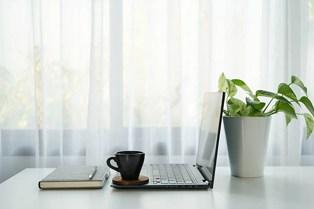 istock Laptop side view and black coffee cup and notebook, cozy indoor workspace 2210428811