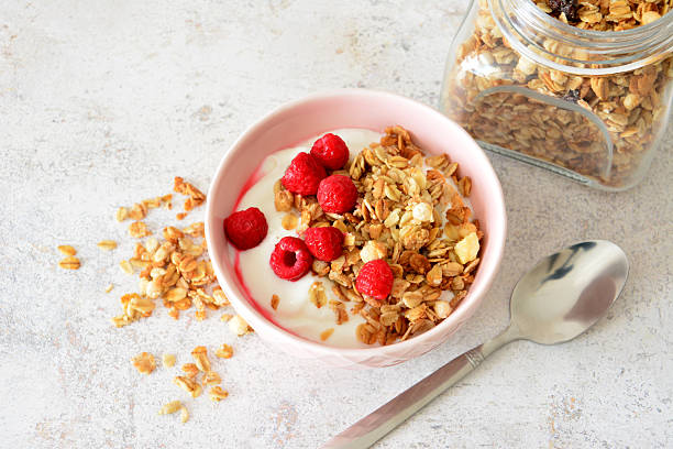 istock flat lay with Granola with yogurt and fresh raspberries in a pink bowl 2210429268