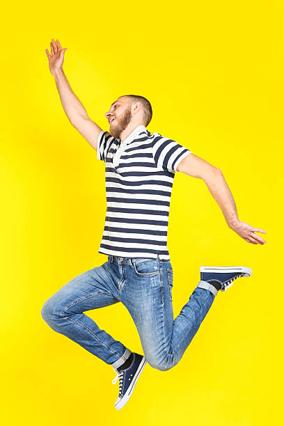 istock Jumping young man on yellow background 2210430578