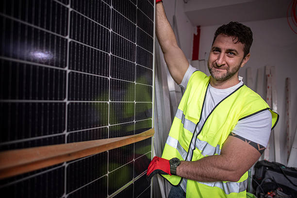 istock Solar panel worker in storage prepare them for installation and looking at camera in warehouse 2210431084
