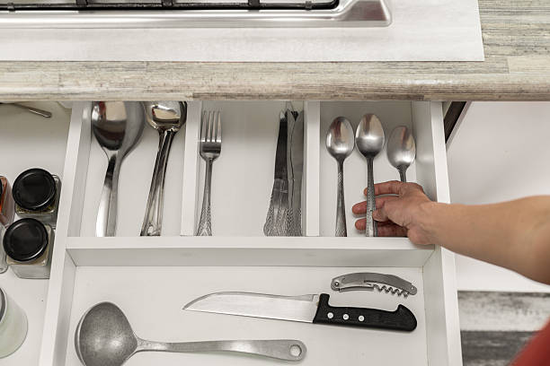 istock Hand Reaching for Spoon in Open Cutlery Drawer 2210431823