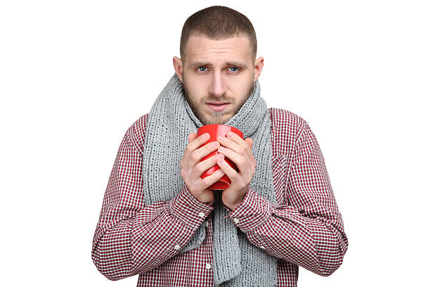 istock Young man feeling sick with scarf and cup on white background 2210432397