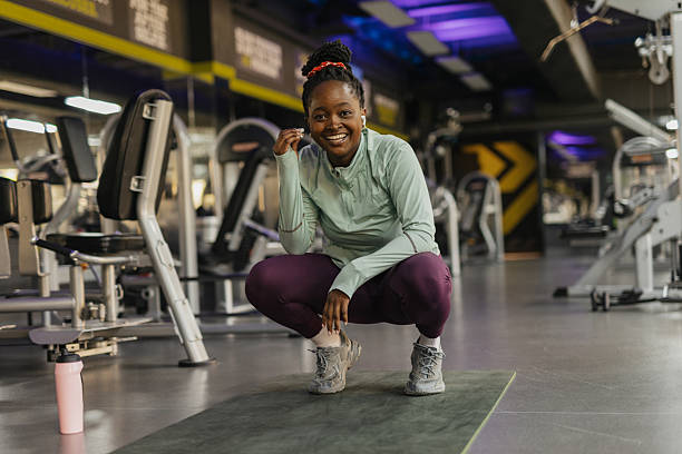 istock Smiling woman crouching on gym mat, workout gear. 2210434285