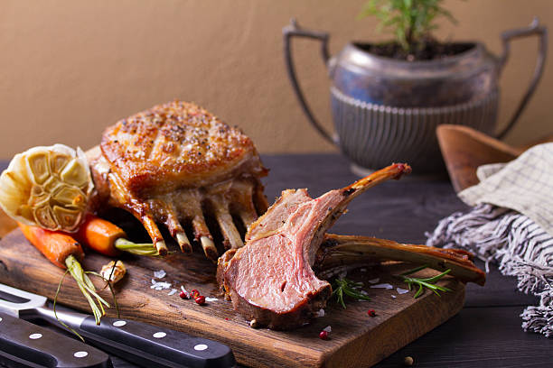 istock Roasted rack of lamb. Lamb chops with vegetables on serving wooden board 2210437075