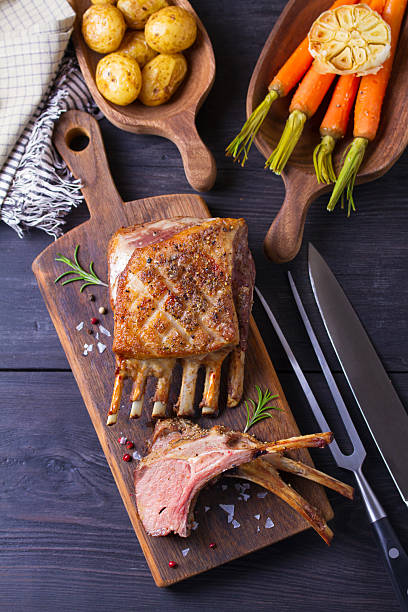 istock Roasted rack of lamb. Lamb chops with vegetables on serving wooden board 2210437128