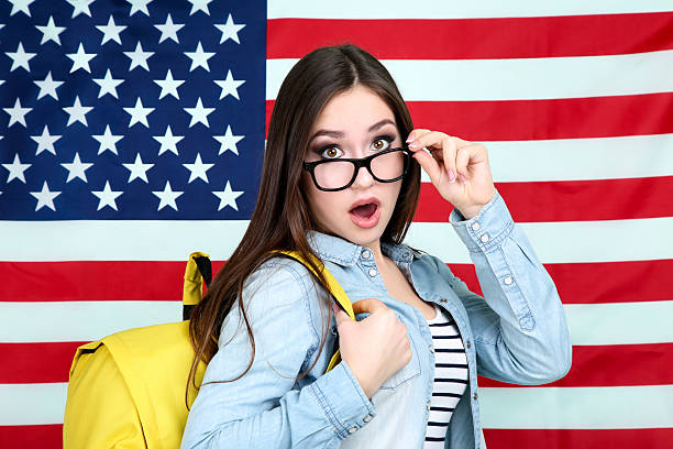 istock Young student with backpack on American flag background 2210440369