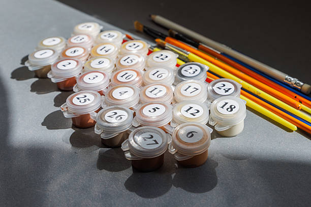 Numbered paint cans and brushes on a gray background. Painting by numbers. Creative hobby. Brushes and paints Numbered paint cans and brushes on a gray background. Painting by numbers. Creative hobby. Brushes and paints. High quality photo Paint by Numbers Kits stock pictures, royalty-free photos & images