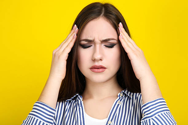 istock Young woman having headache on yellow background 2210441893