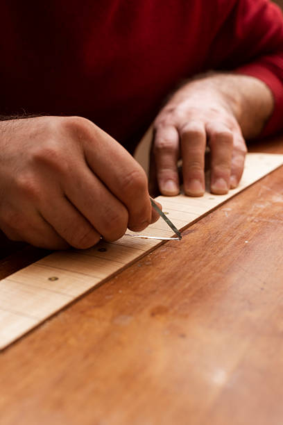 istock A musical instrument maker peels off a thin layer of guitar neck using glass 2210448170