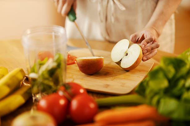 istock Cropped picture of hands cutting apple on cutting board. 2210452994