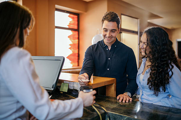 istock Young couple paying at hotel reception with credit card 2210454584