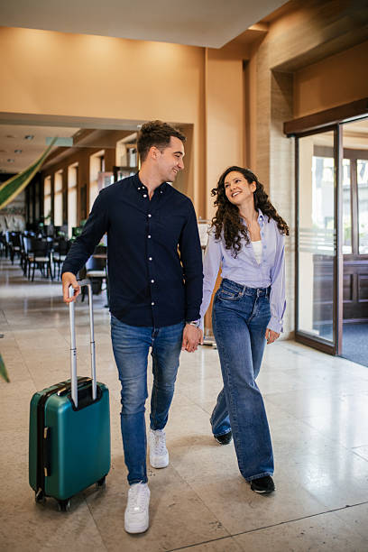istock Young couple entering hotel lobby for check in 2210454885
