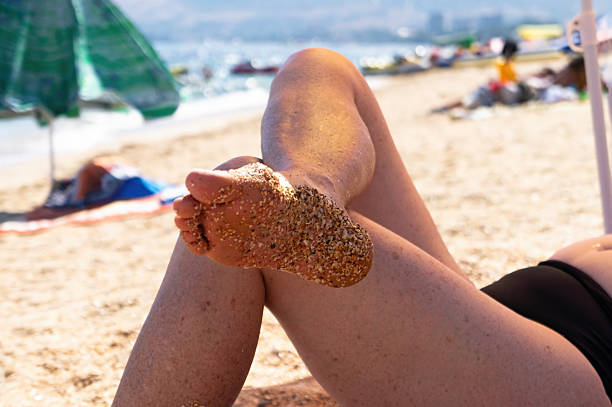 istock Close-Up of Elderly Woman's Legs Sunbathing on the Beach 2210455567
