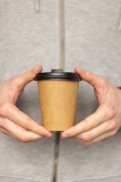 istock Man holding a craft disposable paper cup with fresh coffee. 2210456663