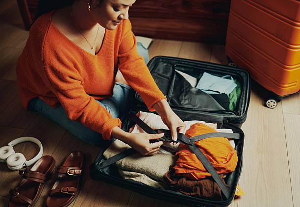 istock Woman Packing Clothes in a Suitcase 2210456895